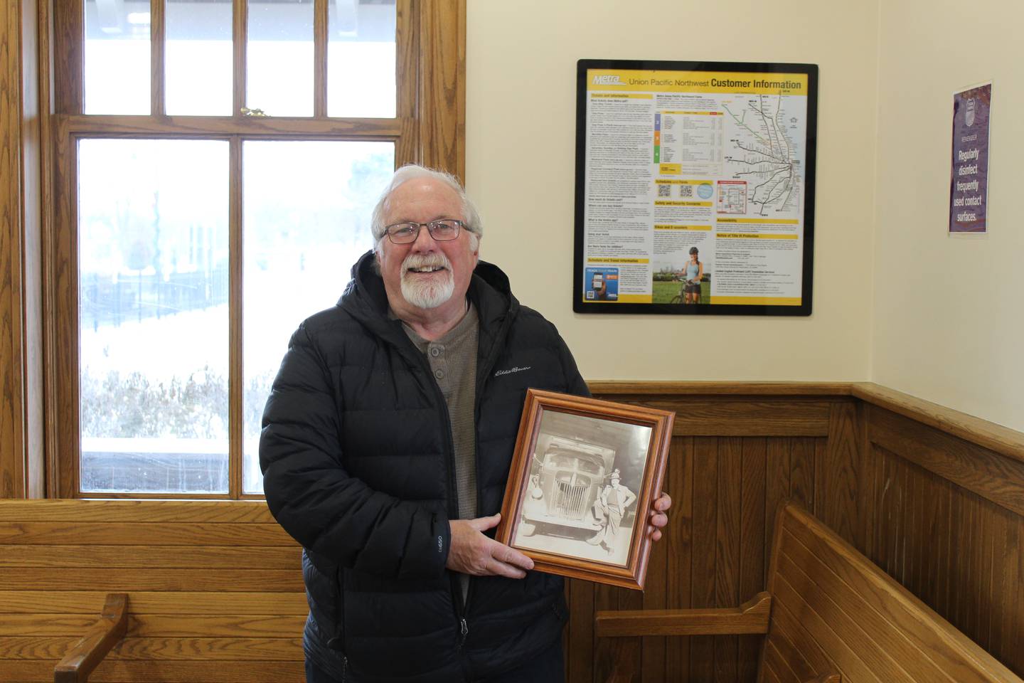Crystal Lake Historic Preservation Commission member Robert Wyman stands inside the Crystal Lake depot holding a photo of his father, Willis Wyman, who returned home from WWII at the station.