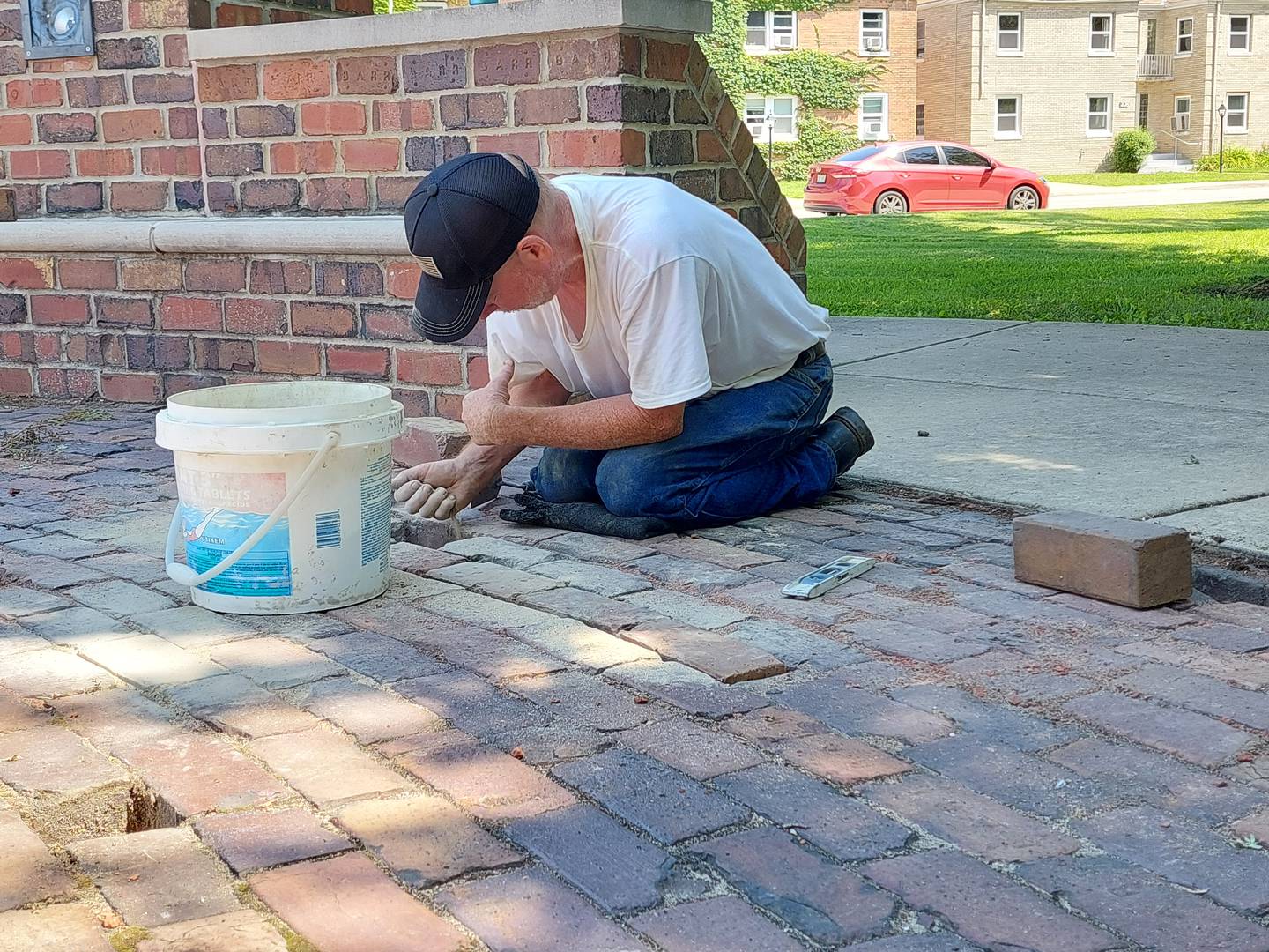 Volunteer David Pierece, of Ottawa, works on repairing broken bricks Friday, July 14, 2023, at the Reuben Soderstrom Plaza in Streator.