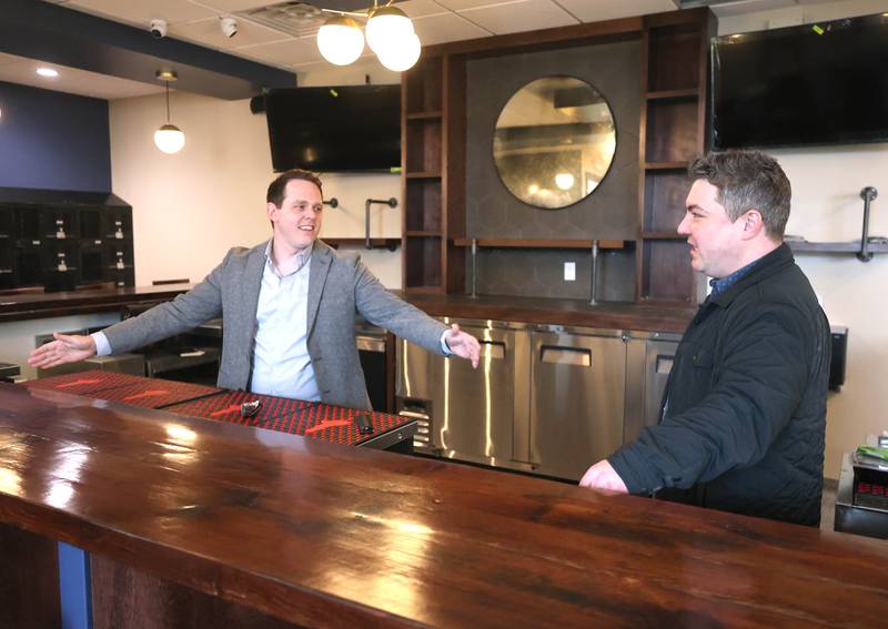 The Grove restaurant and bar owners Sam Patterson (left) and Jason Engstrom talk about the reclaimed barn wood that was used to create the bar Thursday, March 23, 2023, during a tour of the new eatery in DeKalb. They plan to open their doors upon completion within the next few weeks.