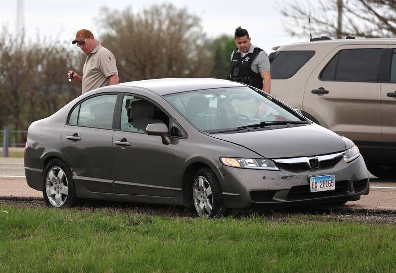 Law enforcement officials look into a Honda sedan with a shattered window in the westbound lanes of Interstate 88 Monday, April 27, 2026, as they investigate an incident on I-88 just west of Keslinger Road in Maple Park.