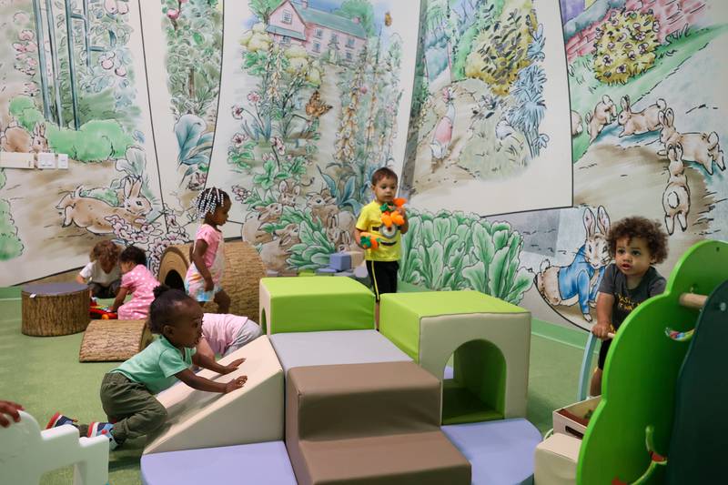 Little ones play inside the Peter Rabbit Bunny Patch, an age-appropriate space for infants and toddlers, in the Exploration Station's new Storybook Forest exhibit on Monday, June 23, 2025, during its grand opening event.