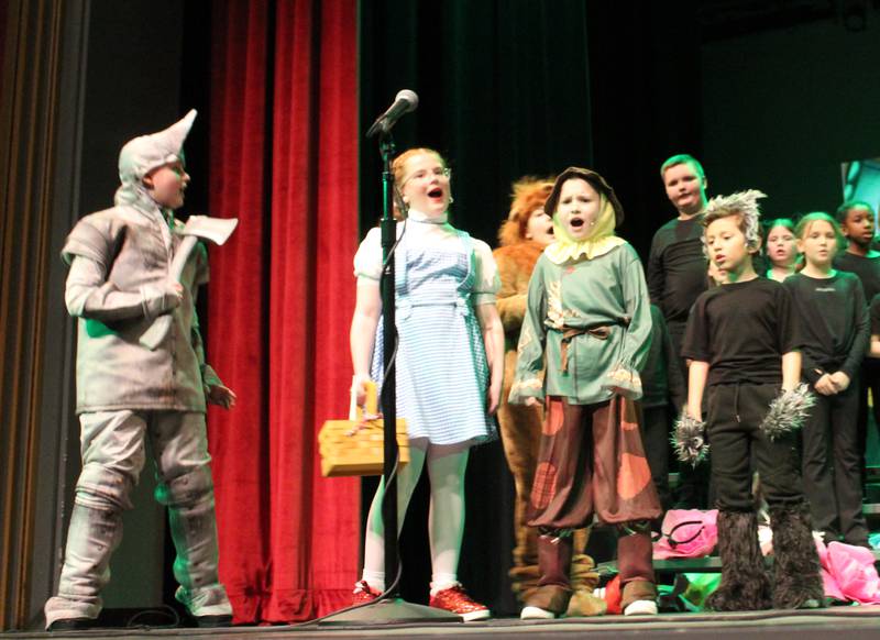 The Tin Man (Braison Kelly), Dorothy (Karsyn Stewart), the Cowardly Lion (Bentley Lurz), the Scarecrow (Jaxton Anderson) and Toto (Leo Gonzalez) perform a musical number Friday, March 22, 2024, during the Streator Elementary Schools production of "The Wizard of Oz – Youth Edition" at Streator High School.