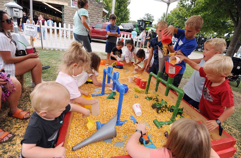 Kids play in a corn box, filled with corn kernels on Thursday, Sept. 5, 2024, at the Sandwich Fair.