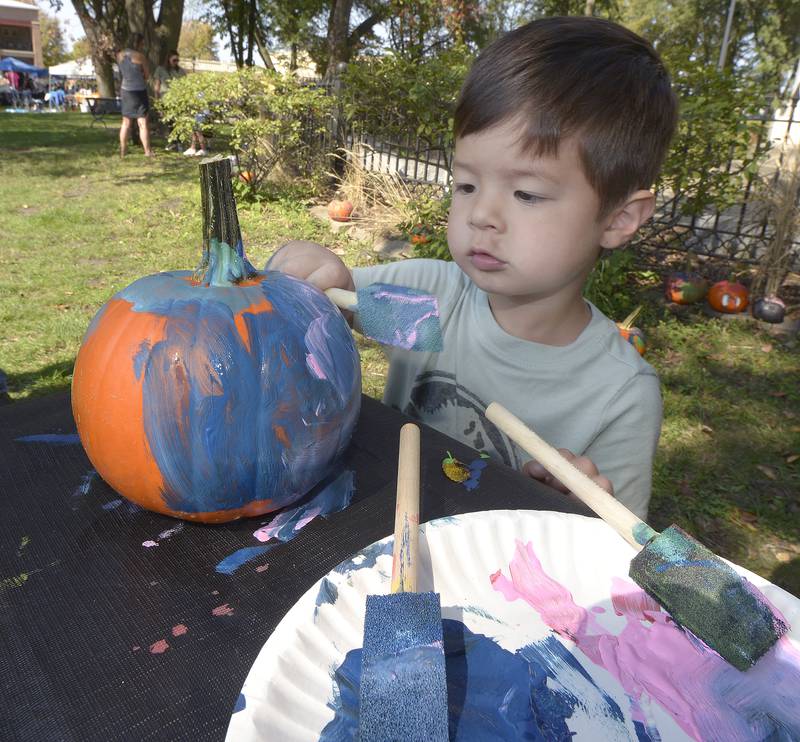 Kit Leitner adds as many colors as possible to his pumpkin as he and other children decorated pumpkins Saturday during the annual Scarecrow Festival in Ottawa.