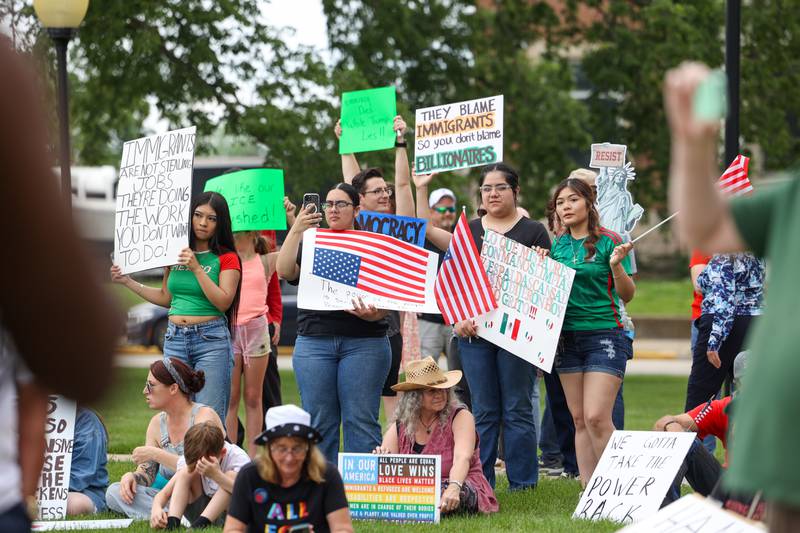 Protesters hold signs on the topic of immigration as approximately 500 people gathered at the Kankakee County Courthouse for a ‘No Kings’ rally in Kankakee on Saturday, June 14, 2025, to protest actions by President Donald Trump.