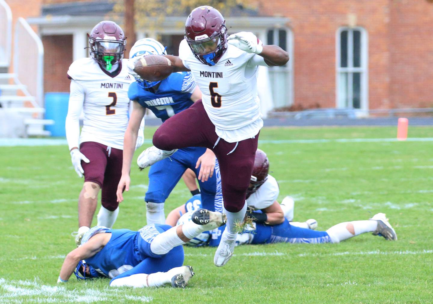 Montini Catholic's Jeremiah Peterson jumps over Princeton's Ace Christiansen to gain extra yards on a run in the first quarter during the Class 3A quarterfinal game on Saturday, Nov. 16, 2024 at Bryant Field in Princeton.