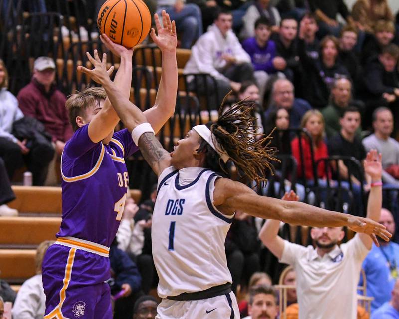 Downers Grove South's Keon Maggitt (1) tries to block the shot of Downers Grove North's Jack Richtman (4) during the game on Saturday Dec. 21, 2024, held at Downers Grove South High School.