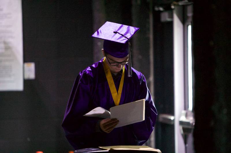Hampshire senior Nicholas Janis reads some papers  before the Hampshire High School graduation ceremony on May 21, 2022, at the NOW Arena in Hoffman Estates.