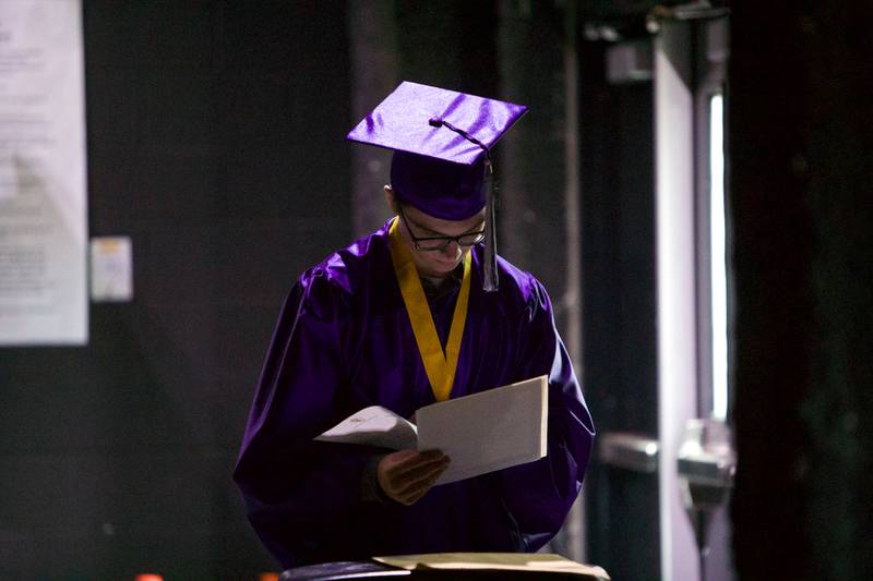 Hampshire senior Nicholas Janis reads some papers  before the Hampshire High School graduation ceremony on May 21, 2022, at the NOW Arena in Hoffman Estates.