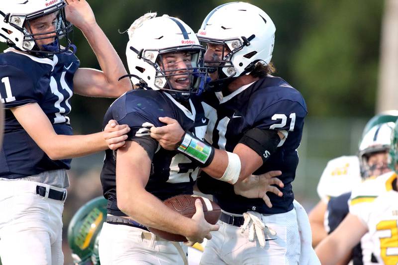 Cary-Grove’s Colin Desmet, center, is all smiles in the end zone after scoring a touchdown as he is greeted by Peyton Seaburg, left, and Mykal Kannelakis, right, at Al Bohrer Field on the campus of Cary-Grove High School Friday night.