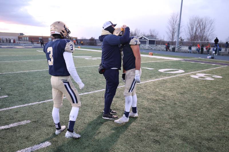 A Lemont coach consoles Joseph DeMaio after a heartbreaking loss to East St. Louis 32-29 in the Class 6A semifinal in Lemont on Saturday.