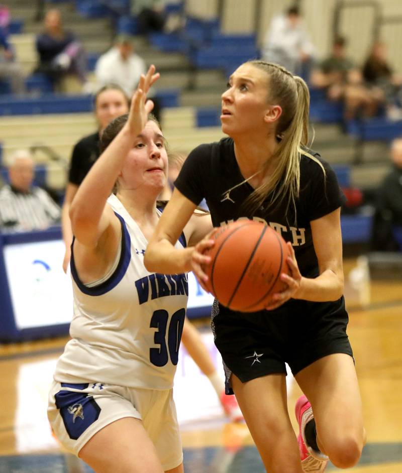 St. Charles North’s Reagan Sipla attempts a shot away from Geneva’s Keira McCann during a game at Geneva on Tuesday, Feb. 6, 2024.