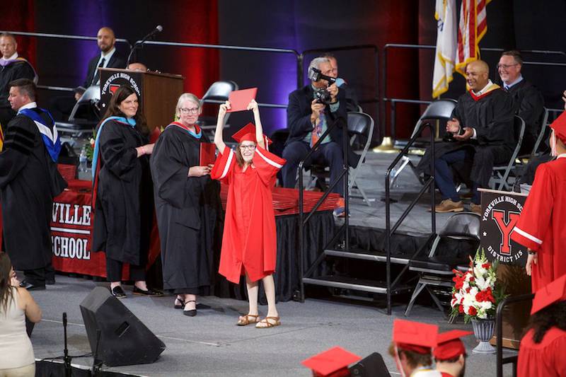 Yorkville High School Graduateholds up her diploma in joy at the Commencement Ceremony at NIU Convocation Center on Friday, May 16, 2025 in DeKalb.