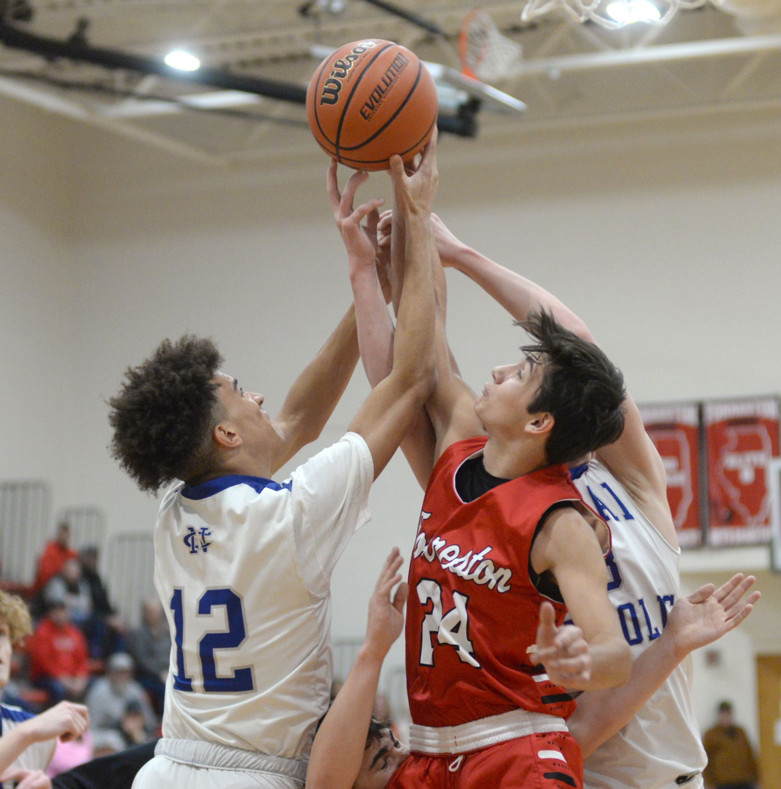 Newman's Isaiah Williams and Forreston's Mickey Probst (left) jump for a rebound at the 62nd Forreston Holiday Tournament at Forreston High School on Saturday, Dec. 16, 2023.