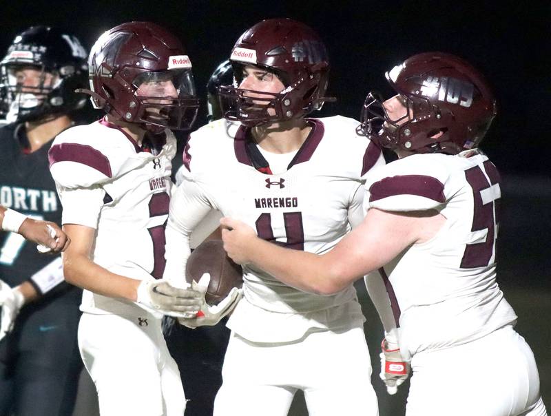 Marengo’s Parker Mandelky, center, is greeted by Cooper Lopez, left, and James Wroble after a Mandelky touchdown against Woodstock North in varsity football at Rod Poppe Field on the campus of Marengo High School in Marengo on Friday, Sept. 12, 2025.