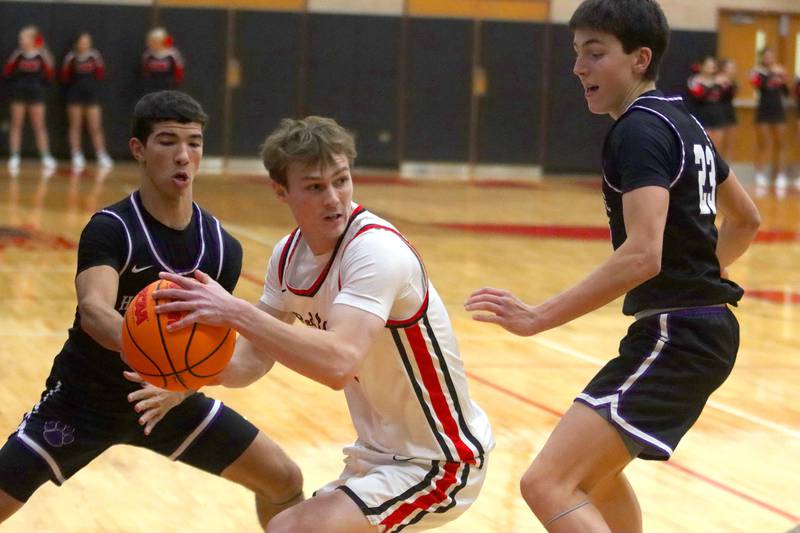 Huntley’s Aidan Gibbs, center, looks for an option as Hampshire’s Jordan Parish, left, and Sean Roth, right, defend in varsity boys basketball on Friday, Dec. 19, 2025, at Huntley High School in Huntley.