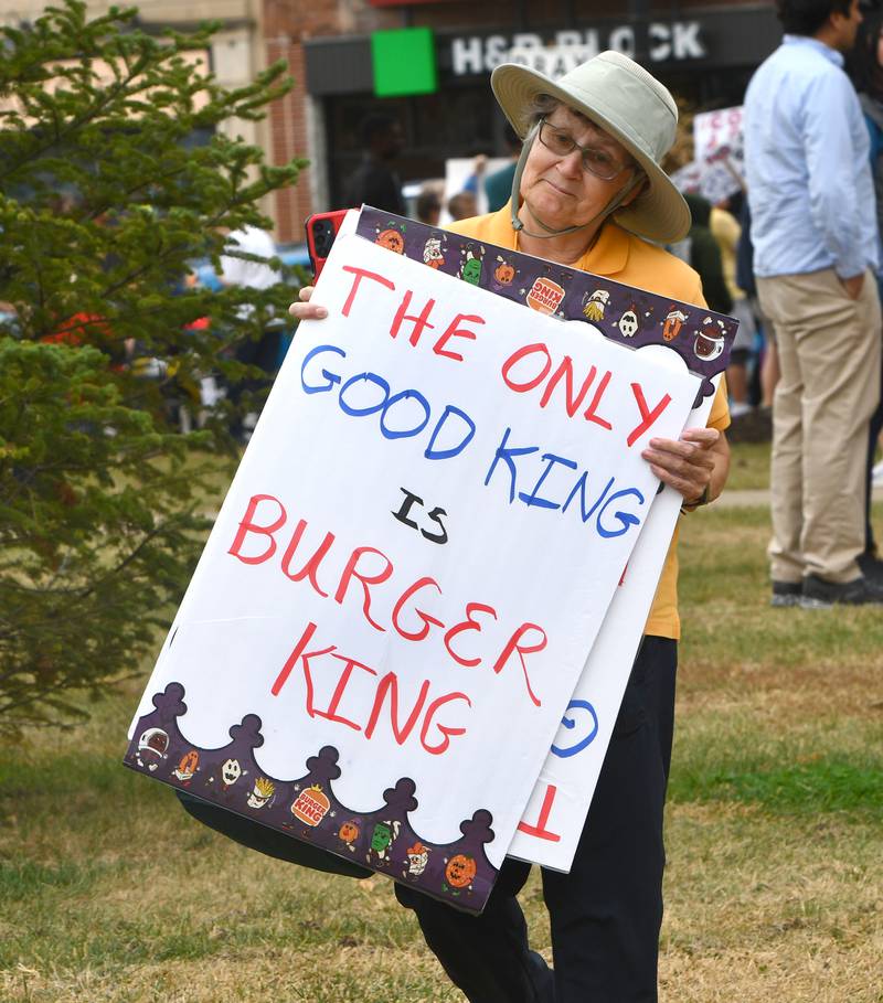 A woman carries a sign at the No Kings rally on Saturday, Oct. 18, 2025 on the Ogle County Courthouse square in Oregon, Illinois.