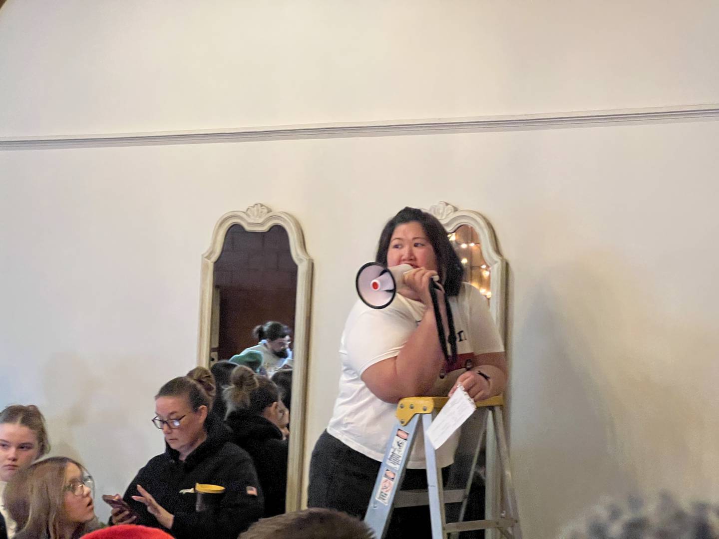 Kelli Meserole, on Dec. 24, 2025, from a ladder inside Blumen Gardens in Sycamore, thanked the Goodfellows of DeKalb and Sycamore for their efforts to give disadvantaged children gifts they needed for Christmas.