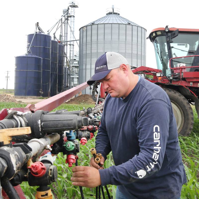 Farmer Mike Schweitzer changes the nozzles on the sprayer tractor in one of his fields Friday, June 16, 2023, on his farm in Malta.