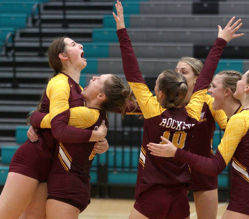 Richmond-Burton’s Rockets celebrate a three-set win in varsity volleyball at Woodstock North Monday night.