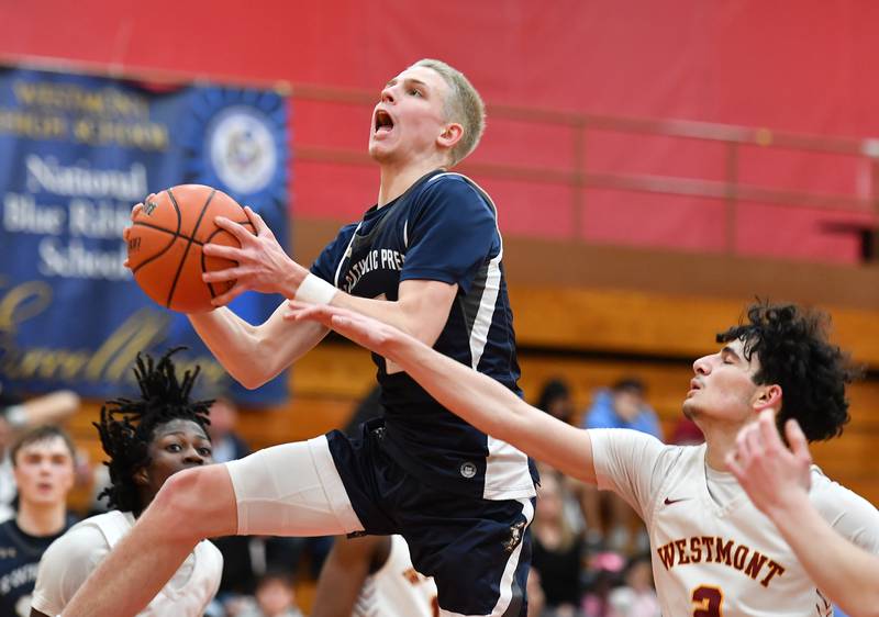 IC Catholic's Aidan Johnson takes the ball to the basket as Westmont's Alexander Konof (right) defends during a game on Jan. 5, 2024 at Westmont High School in Westmont.
