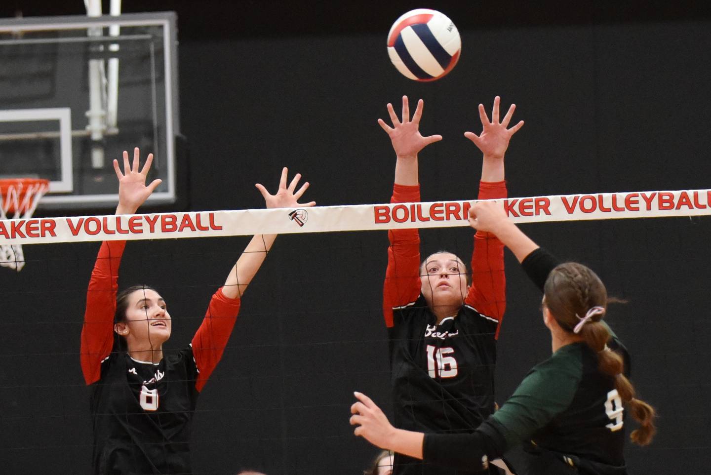 Bradley-Bourbonnais' Hannah Wojnowski, left, and Liv Woolman, center, time their block on a hit from Bishop McNamara's Carley Johnson during All-City action at Bradley-Bourbonnais Wednesday, Sept. 10, 2025.