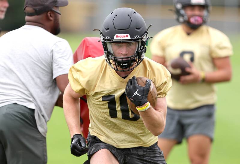 Sycamore's Zack Crawford carries the ball Monday, Aug. 8, 2022, at the school during their first practice ahead of the upcoming season.