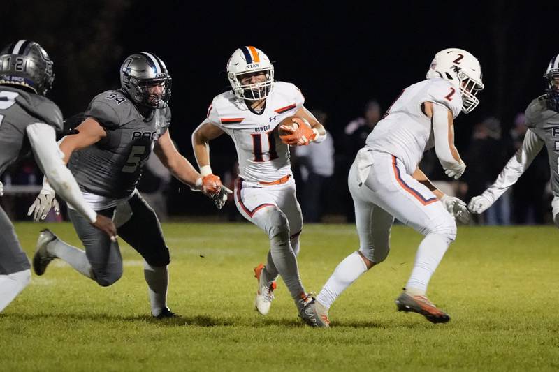 Oswego’s Theodore Manikas (11) carries the ball against Oswego East during a football game at Oswego East High School on Friday, October 25, 2024.