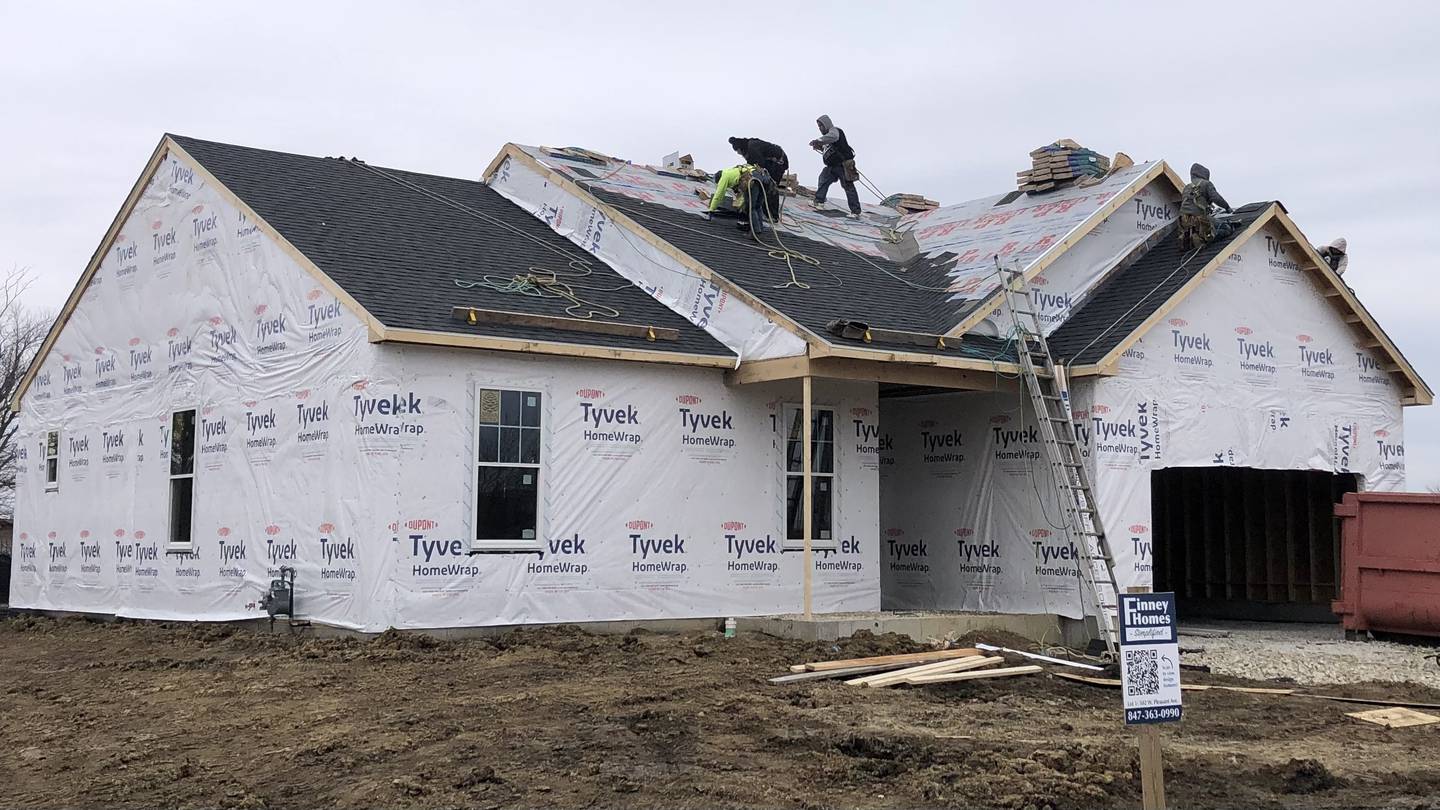 Construction workers install roofing Thursday morning March 16, 2023 on Finney Homes' first home build in Sandwich at 502 W Pleasant St. on the East side of the Fairwinds subdivision.