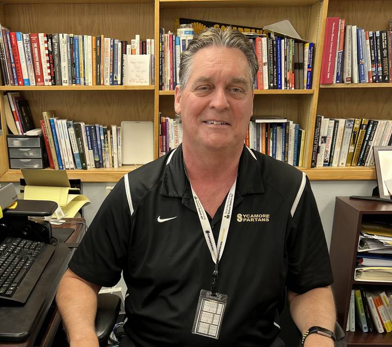 Tim Carlson, 59, of Sycamore, sits at his desk in Sycamore High School on April 14, 2023. Carlson has worked a variety of jobs for Sycamore Community School District for the past 31 years but will retire this summer.
