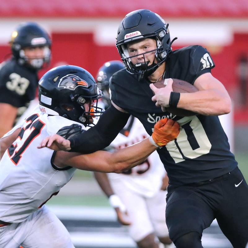 Sycamore's Burke Gautcher tries to get by DeKalb’s Daniel Roman-Johnson during the First National Challenge game Friday, Aug. 25, 2023, in Huskie Stadium at Northern Illinois University in DeKalb.