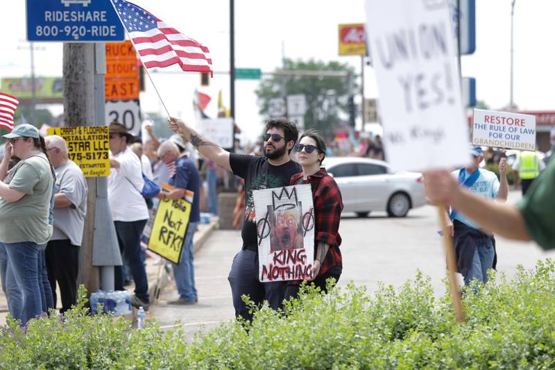 A couple holds an American flag and sign along North Larkin Avenue for the No Kings Day protest on Saturday, June 14, 2025 in Joliet.