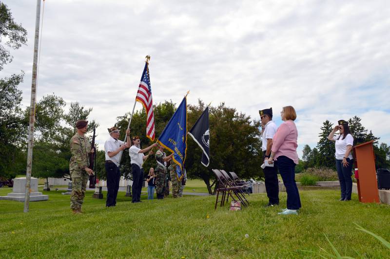 Patrick Fegan American Legion Post No. 83 Commander Cynthia Reynolds, far right; the Rev. Suzanne Hall Stout, of Pine Creek Christian Church, second from right; and American Legion Post No. 83 Executive Officer and Veterans of Foreign Wars Post 8455 member James Reynolds recite the Pledge of Allegiance while facing Polo's Color Guard during the city's Memorial Day ceremony on May 29, 2023, in Fairmount Cemetery.