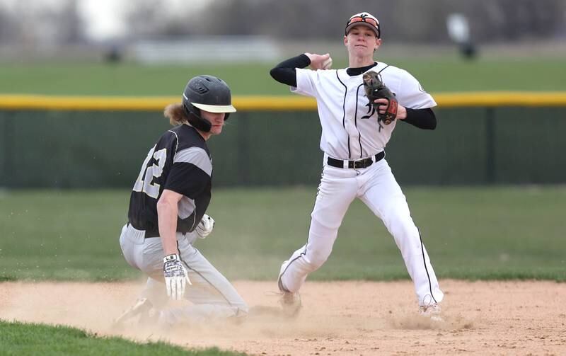 Kaneland's Kyle King tries to turn a double play as Sycamore's Griffin Hallahan slides in to break it up during their game Wednesday, April 27, 2022, at Kaneland High School in Maple Park.