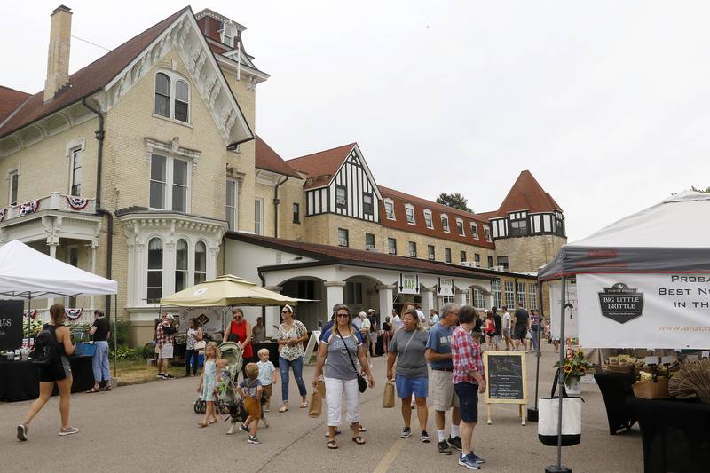 Customers peruse the goods at the farmers market outside the Dole Mansion on Sunday, June 20, 2021, in Crystal Lake.  The farmers market is new to the Dole this year, having never had one there before this month.