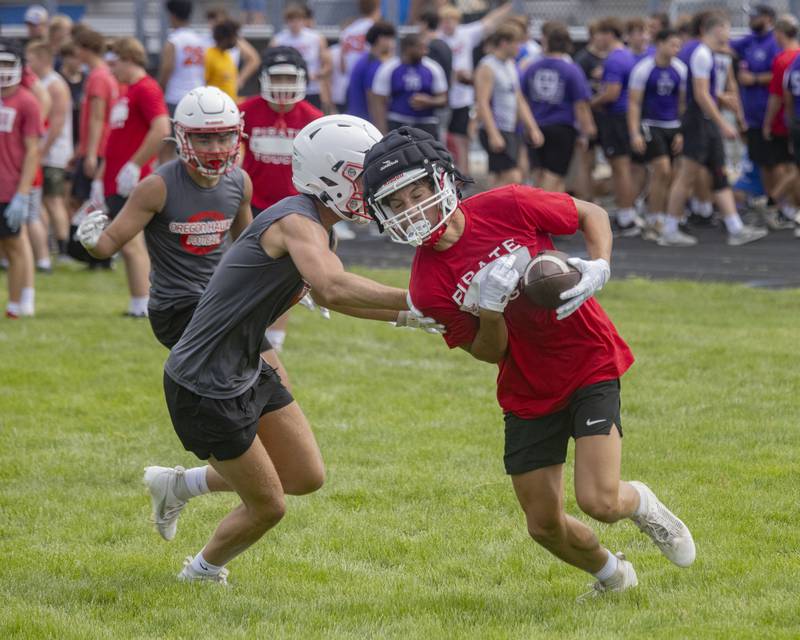 Joey Liebhart of Ottawa High School runs downfield against the Oregon defender during a multiple high school practice football meet at Princeton High School on July 20, 2024.