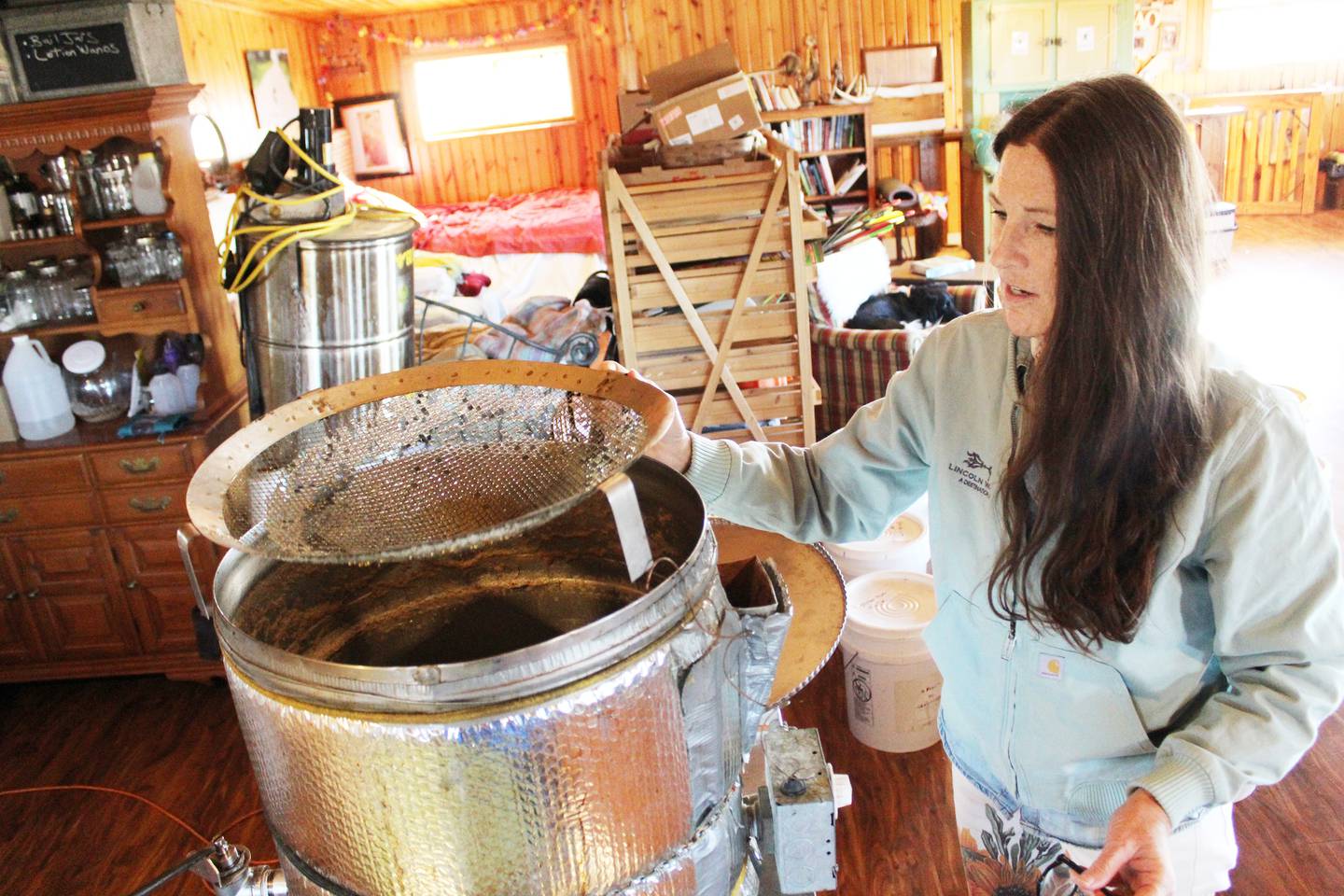 Lisa Ayers and her husband John own Nomia Meadows Farm north of Franklin Grove, where they preserve 110 acres of prairie, grow apples in an orchard and collect and sell honey from bees they raise. Lisa shows off the bottling tank used to put honey in jars they sell at local stores or by appointment.