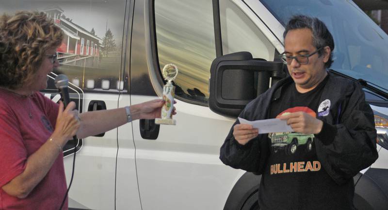 Teddy DeLaCruz of Wood Dale gets a $100 check from Melinda  Jones for winning the taco eating contest. The Taco Throwdown Events Sponsored by Rock Falls Tourism. Event at RB&W District September 27th, 2024.