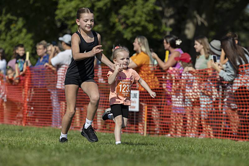 Makynlee Shipma, 9, runs with cousin Olivia Rayne Shepard, 3, Saturday, Sept. 30, 2023 in the Sterling Park District Pumpkin Dash at Hoover Park. This was the 31st year of the event.