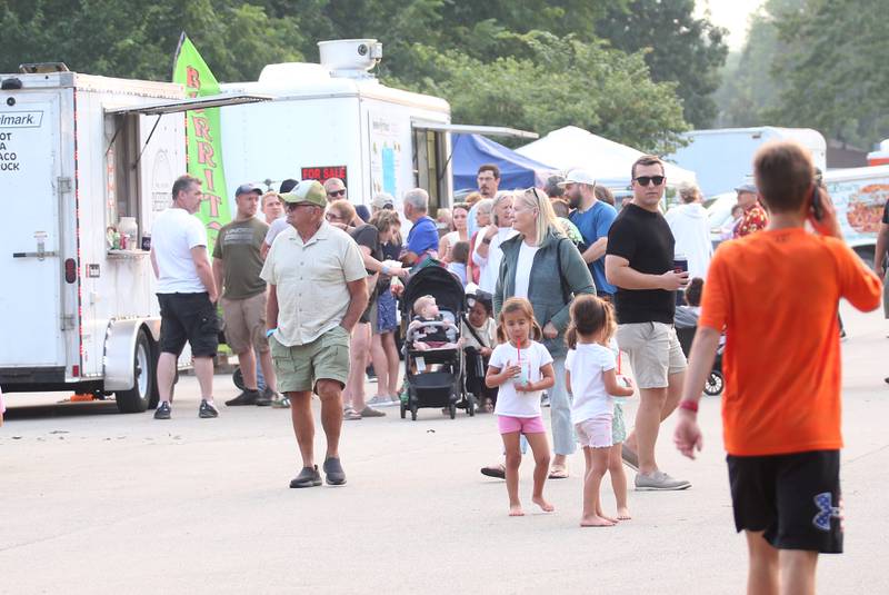 People line up in front of food trucks during the The Taste of the Illinois Valley on Friday, Aug. 1, 2025 at Centennial Park in Peru. The event featured food vendors, live music, a beer tent and a kids zone, Dreamwave wrestling and Pandora's Box, a Aerosmith tribute band.