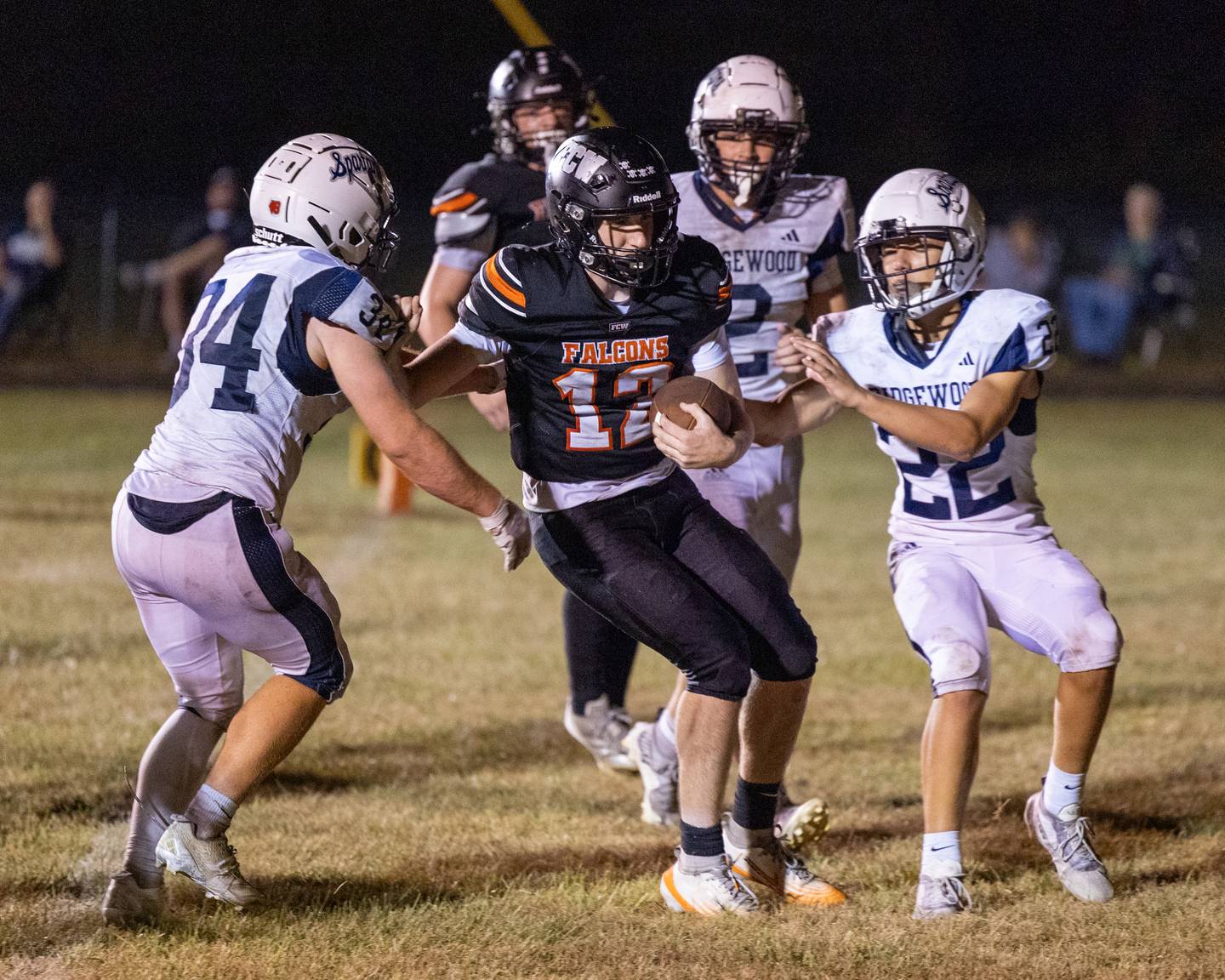 Logan Ruddy (12) of FCW runs ball as Gavin Franks (34) of Ridgewood and teammate Crew Roberson (22) attempt to tackle him Friday, Sept. 26, 2025, at Woodland School in rural Streator.