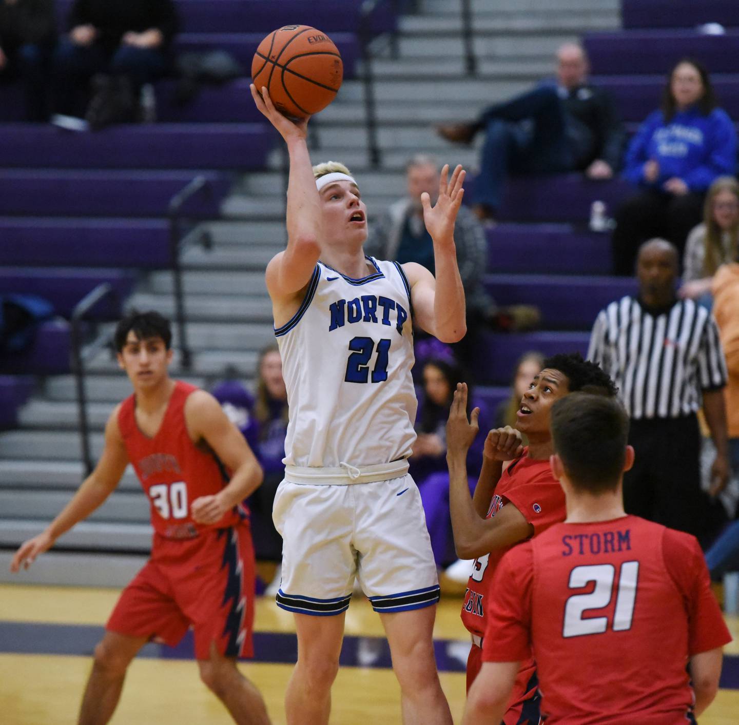 St. Charles North's Max Love (21) takes a shot over a host South Elgin defenders during WednesdayÕs Class 4A Hampshire regional semifinal boys basketball game.