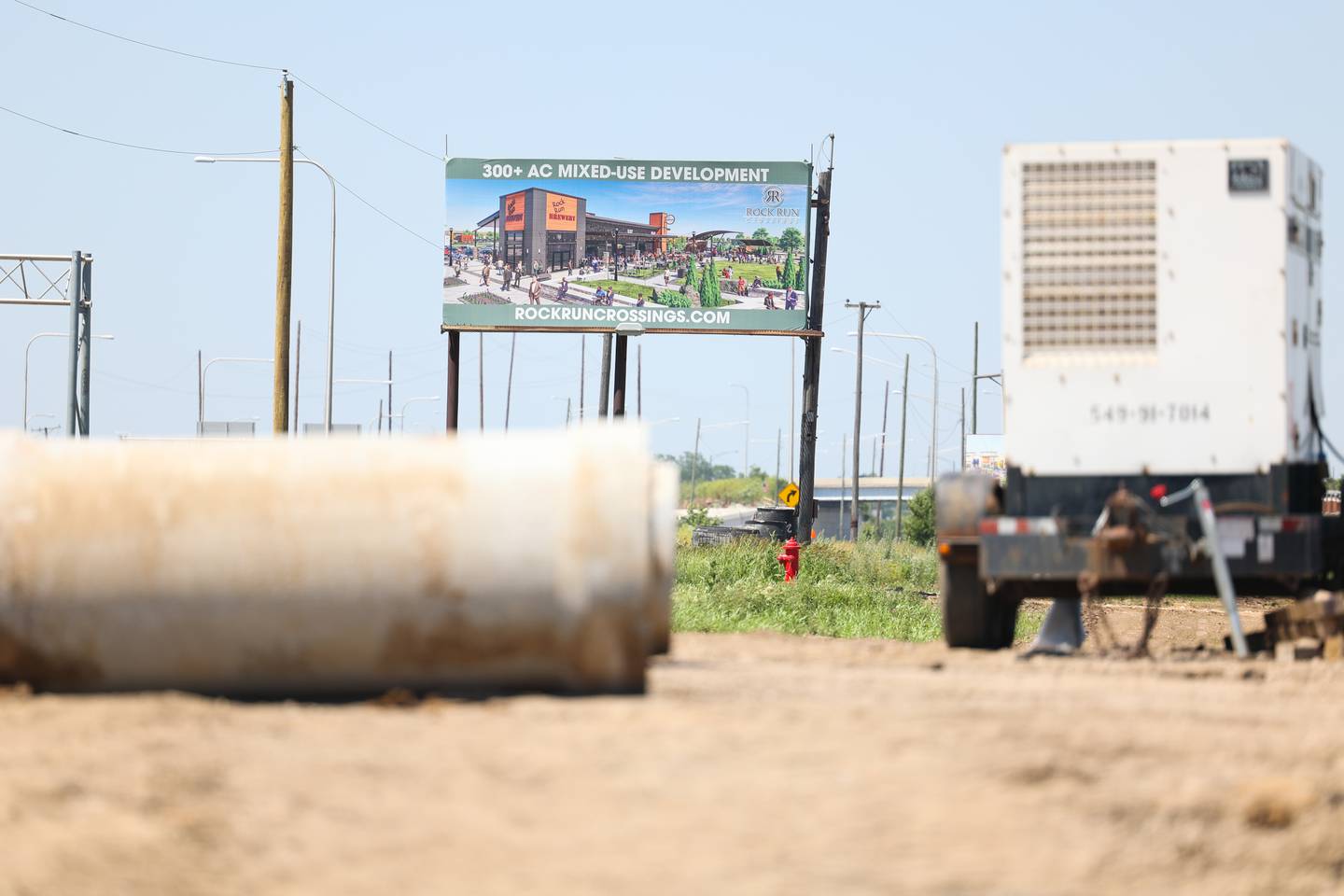 A sign to attract businesses sits in the background of construction at the site of the 310 acre Rock Run Crossing mix-use project near the intersection of I-55 and I-80. Tuesday, June 21, 2022 in Joliet.