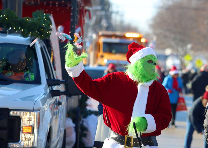 The Grinch tosses candy to youngsters during the Merry Cary Christmas Parade in Cary on Sunday, Dec. 7, 2025 in Cary.