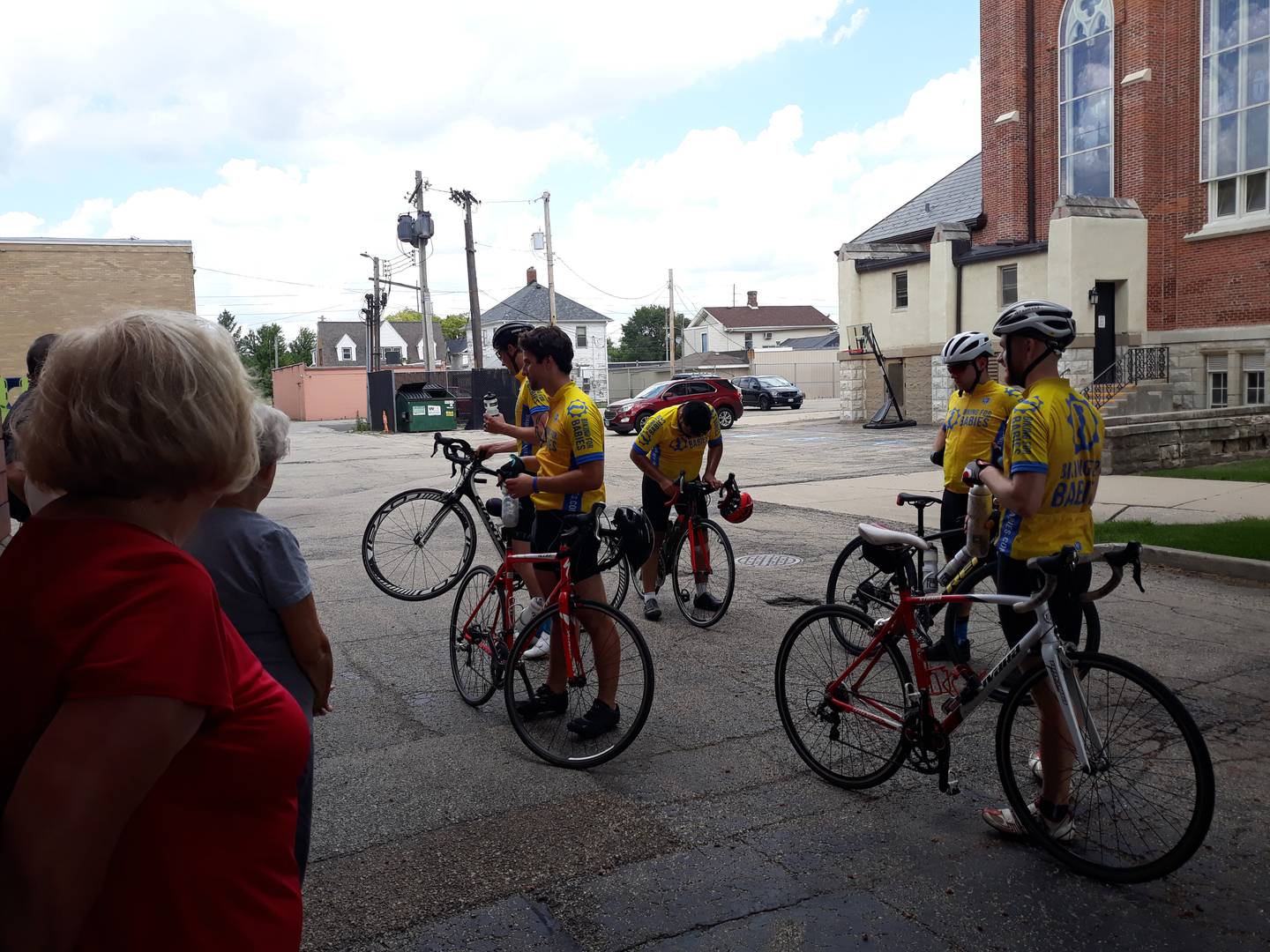 Bicyclists of Biking for Babies talk to parishioners who greeted them Wednesday, July 13, 2022, outside of the St. Columba rectory in Ottawa.