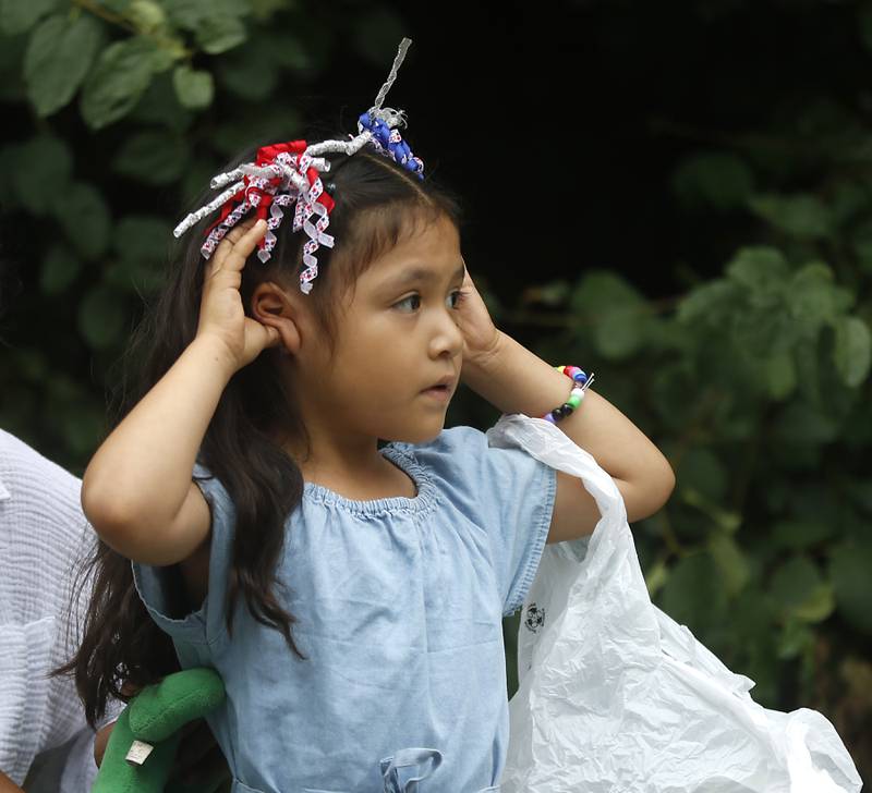 Avery Silva 4, of Crystal Lake plugs her ears as the fire trucks pass Sunday, July 2, 2023 during Crystal Lake’s annual Independence Day Parade on Dole Avenue in Crystal Lake. This year’s parade feature close to 100 units.