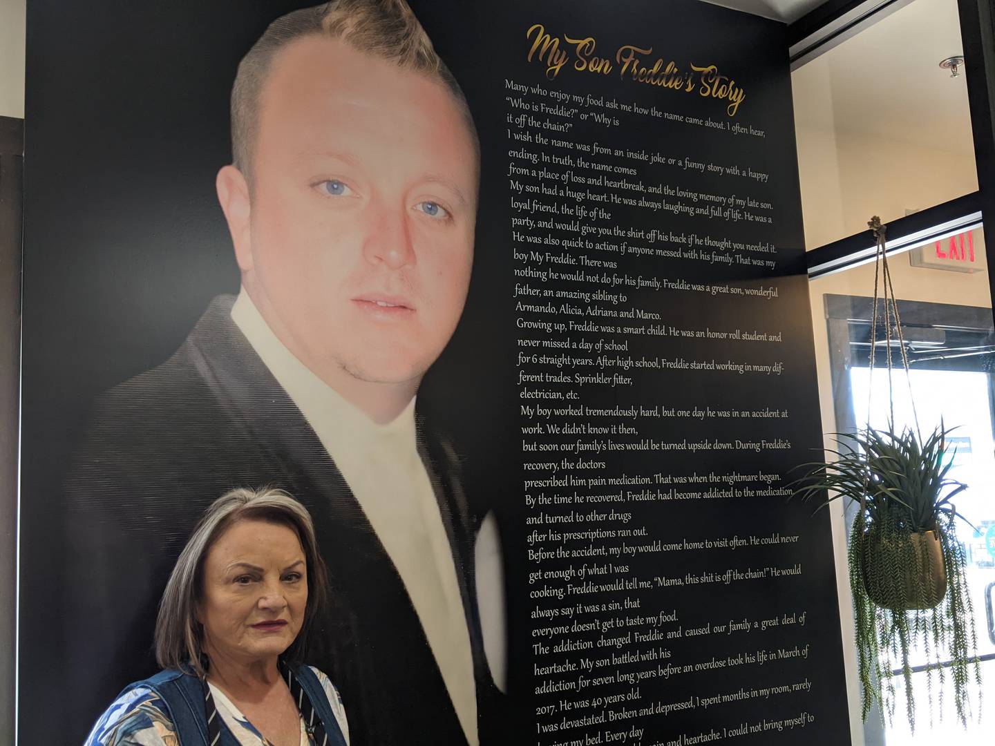 Freddie’s Off The Chain owner Mona Herrada stands next to a photo of her late son, who passed away in March 2017 at the age of 40.