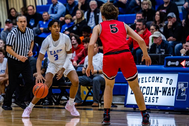 Lincoln-Way Easts  Brenden Sanders navigates around Lincoln-Way Centrals Jack Novak Friday Dec. 2, 2022 at Lincoln-Way East  High School in Frankfort