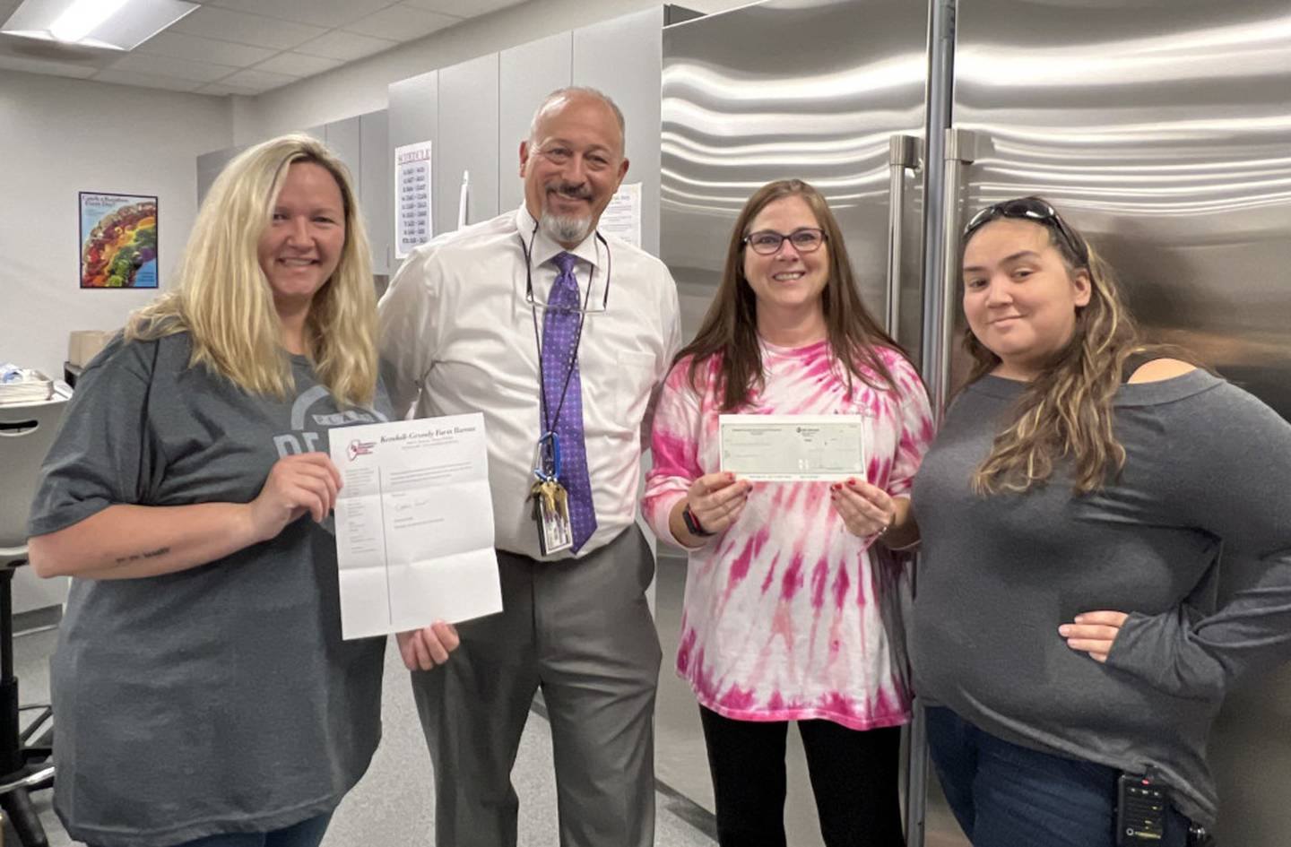 Plano High School Principal Jim Seput, presents a $1,000 check to Family & Consumer Science teachers Kelly Furr, Wendy Smith and Erin Martinez.