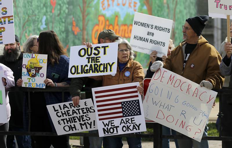 Protesters line U.S. Route 12 in Richmond to protest their discontent with President Donald Trump and his administration's policies on Saturday, April 19, 2025. Over 100, people took part in the Richmond protest. A second rally was held in Harvard later in the day.